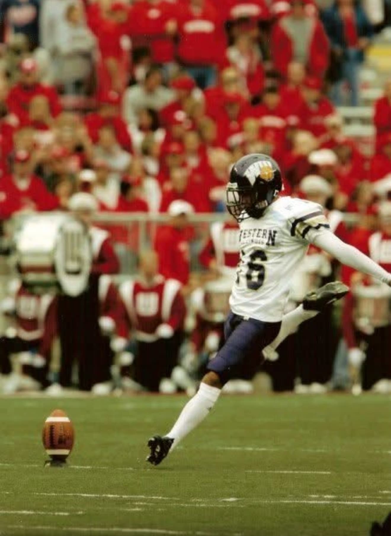 Taylor Rowan kicking a football during a college football game